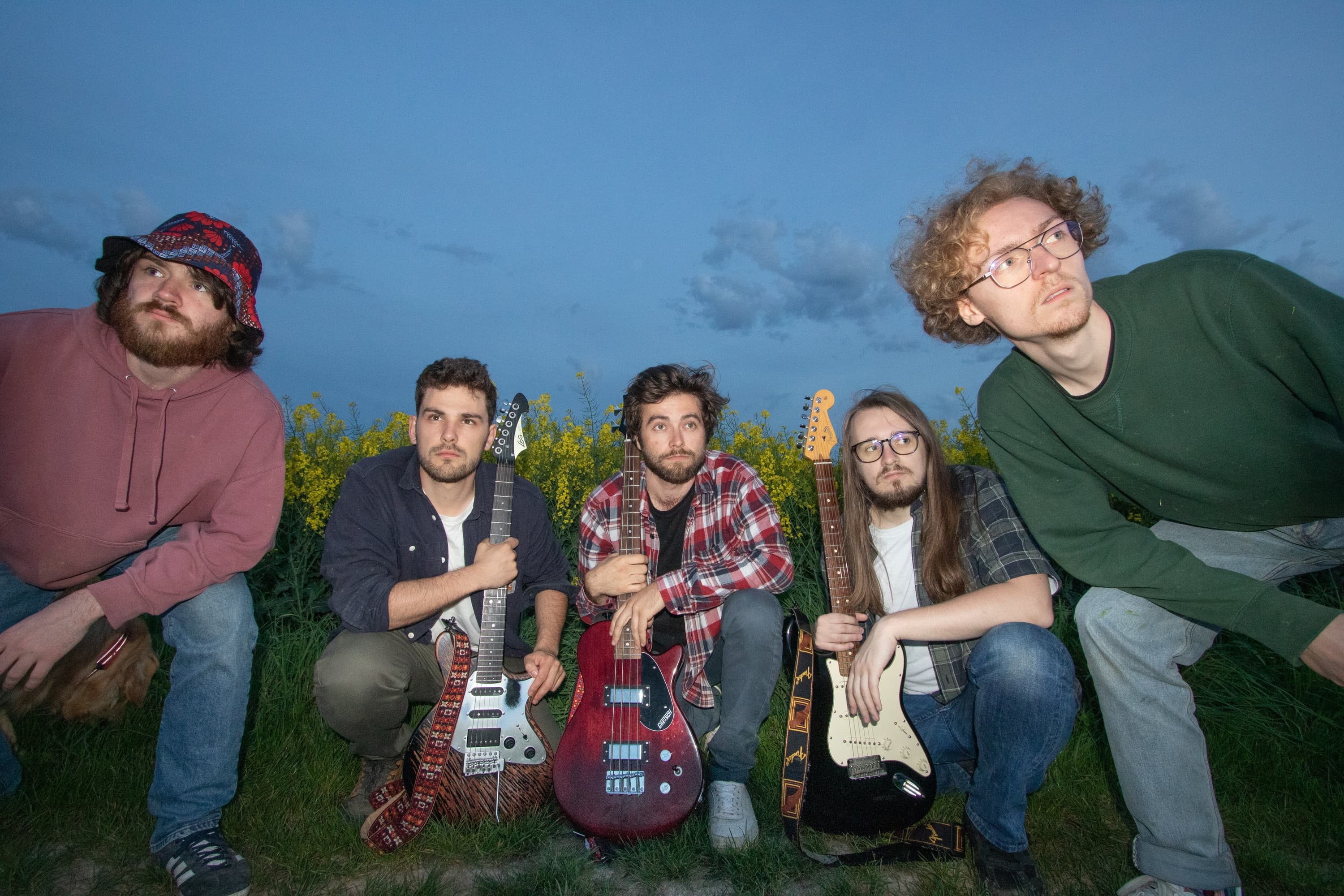 Group members in a field at dusk looking at something out of the frame